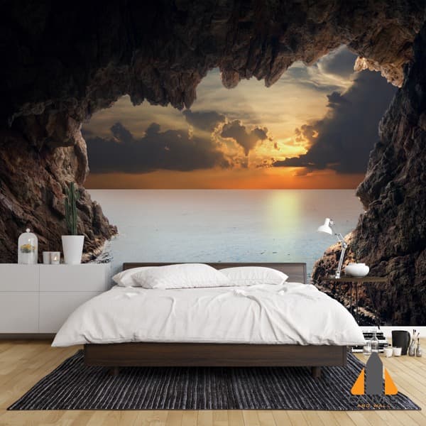 Dramatic sea cave wall mural in a modern bedroom, with a view of the sunset over the ocean.