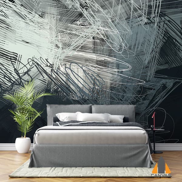 Modern abstract scribble wall mural in a bedroom with a grey bed and green plant.