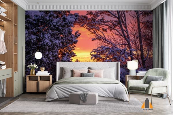 Winter sunset wall mural in a modern bedroom, with snow-covered trees and warm sky hues.