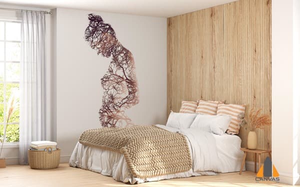 Nature-inspired wall mural of a pregnant woman made of branches in a bedroom.