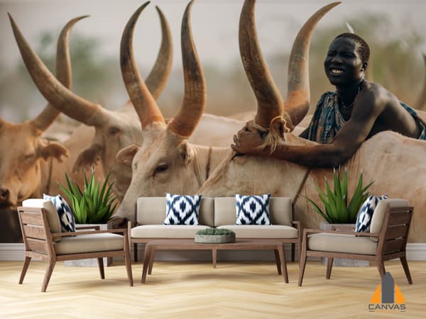 Man from Mundari tribe on back of Ankole cow