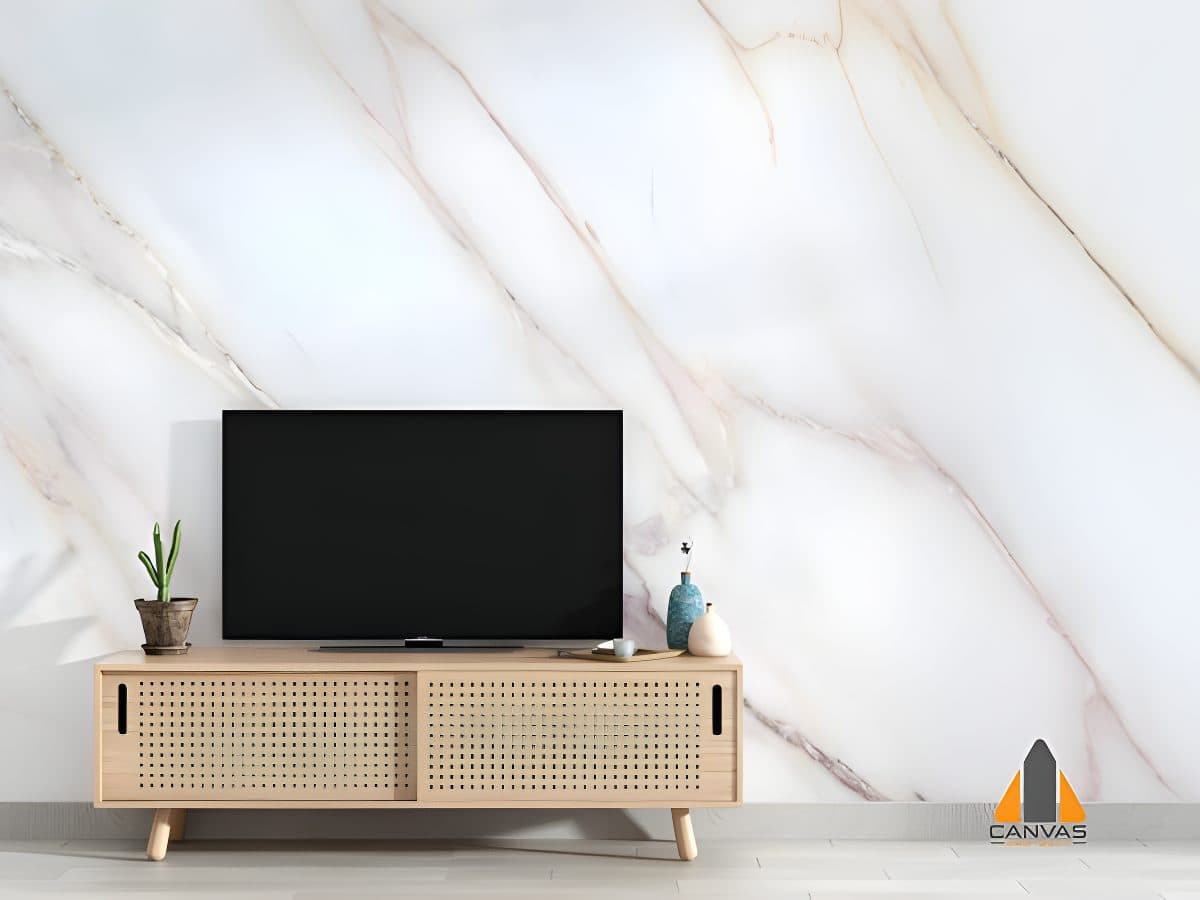 TV console with a cactus and vases in front of a white and pink marble-patterned custom wallpaper.