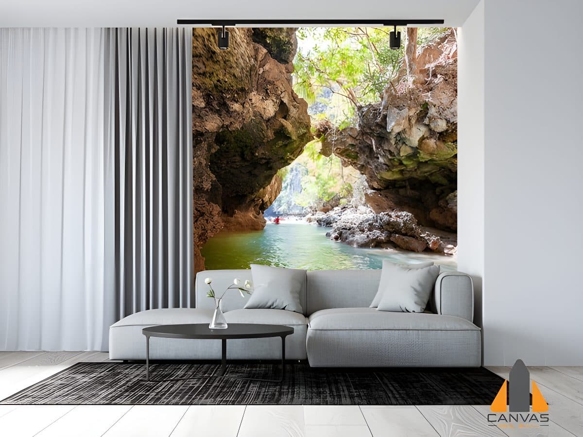 Cave opening overlooking a water passage wall mural in a modern living room with a grey sofa.