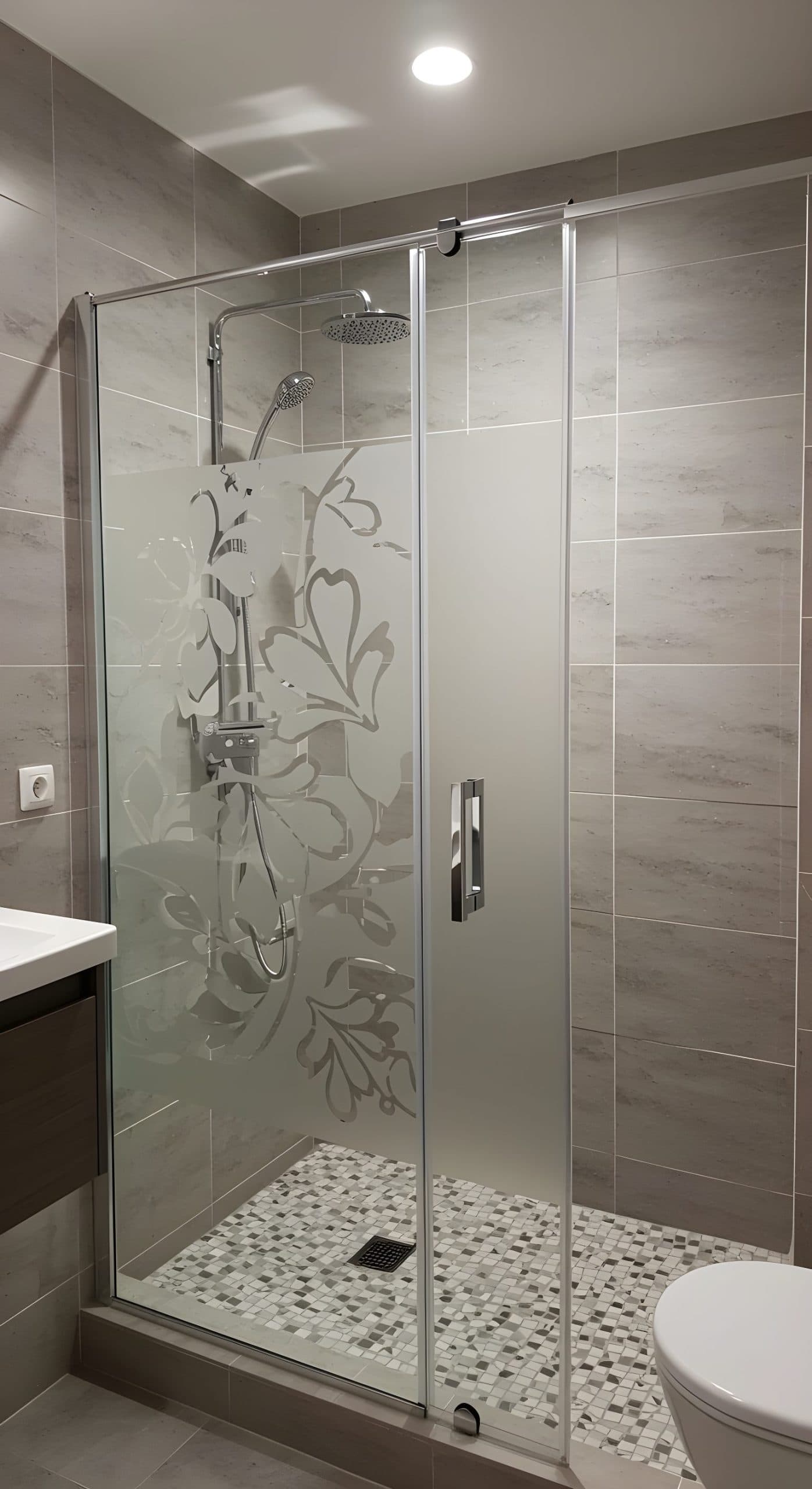Shower enclosure with frosted glass depicting ornate scrollwork, offering privacy and style for your custom wallpaper install