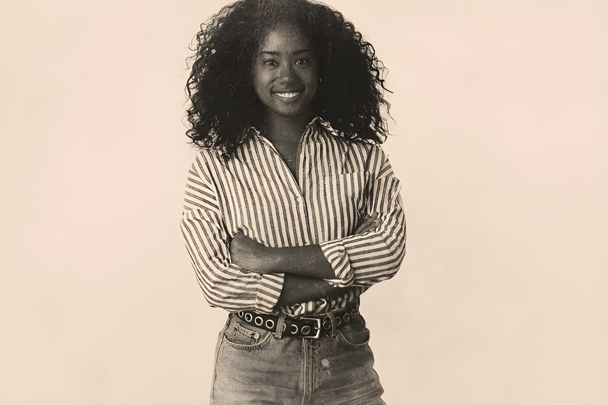 Smiling woman with curly hair in a striped shirt, presented as a vintage effect canvas print artwork.