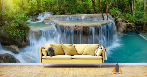 Lush Thai waterfall wall mural in a modern living room with a yellow sofa.