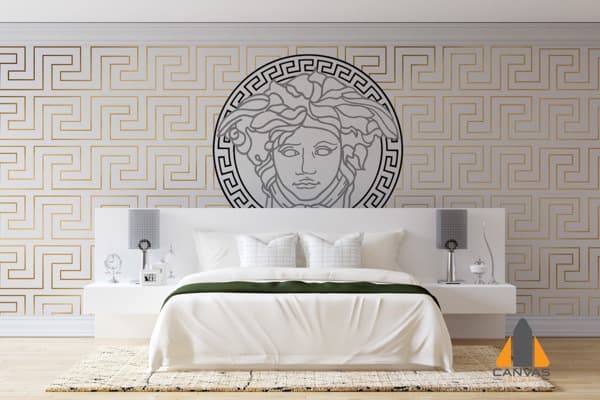 Versace Medusa head custom wall mural above a white bed, with golden geometric wallpaper in a stylish bedroom.