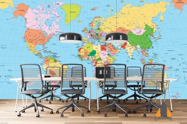 Colorful world map wall mural in a modern office with sleek chairs and a conference table.