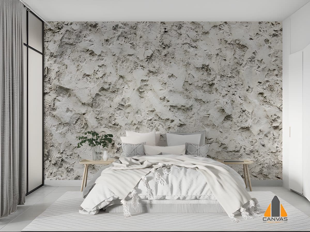 Textured grey wall mural in a modern bedroom with a comfortable bed, demonstrating a wallpaper installation.