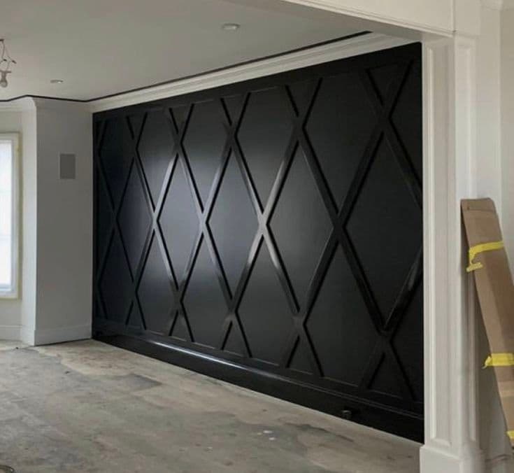Black accent wall with a geometric diamond pattern in a room under construction, ideal for wallpaper installations in Gauteng