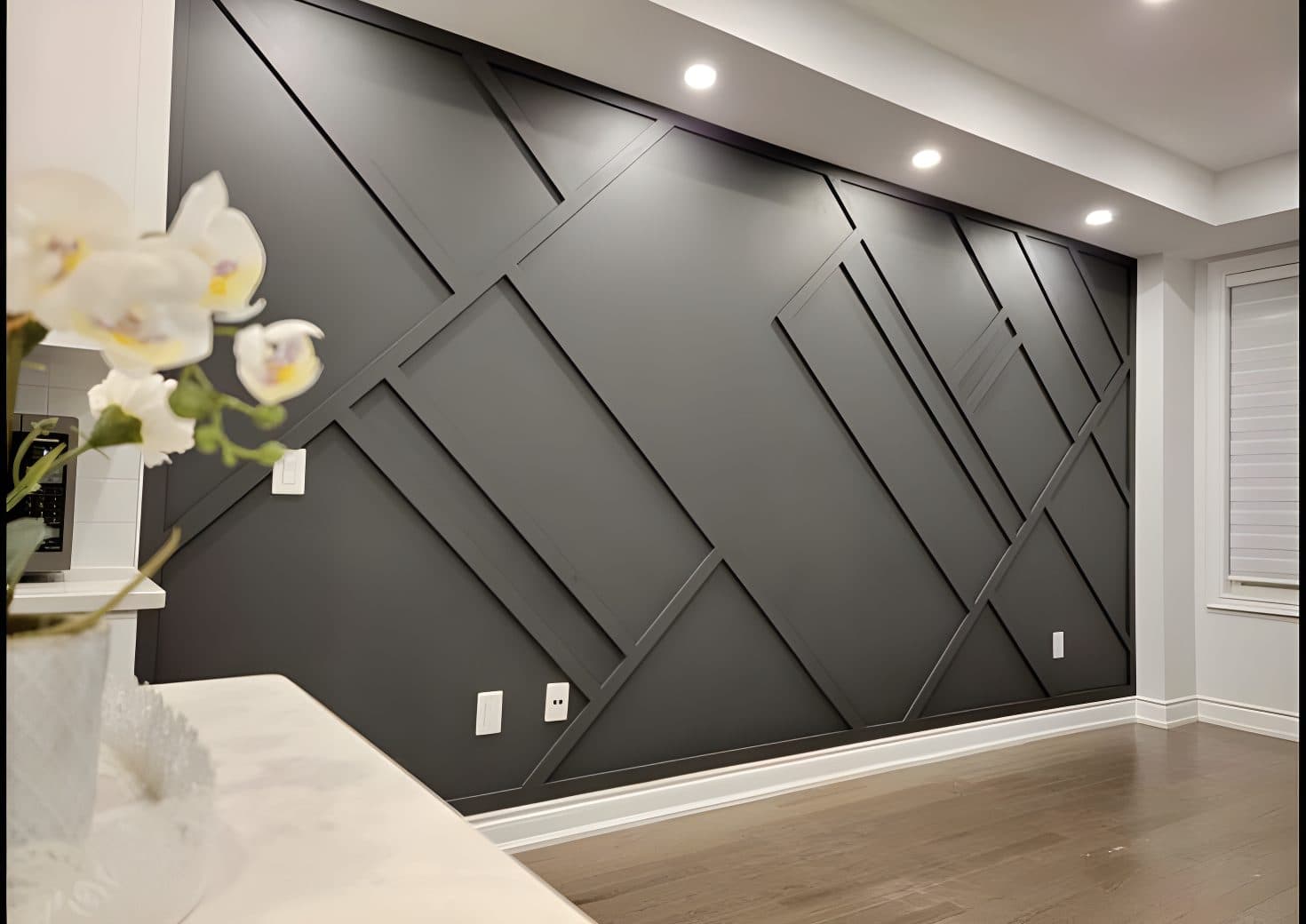 Dark gray accent wall with geometric wood paneling, a stylish custom wallpaper installation.