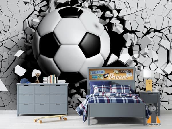 3D soccer ball bursting through a wall mural in a child's bedroom with grey furniture.