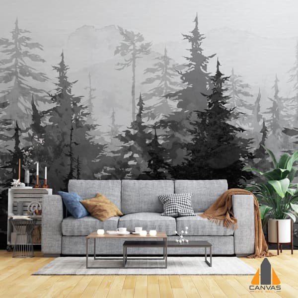 Misty forest wall mural in a modern living room with a grey sofa and potted plant.
