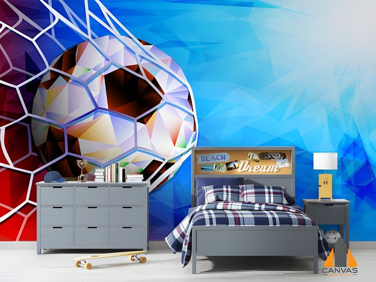 Vibrant soccer ball wall mural in a child's blue and red bedroom with grey furniture.