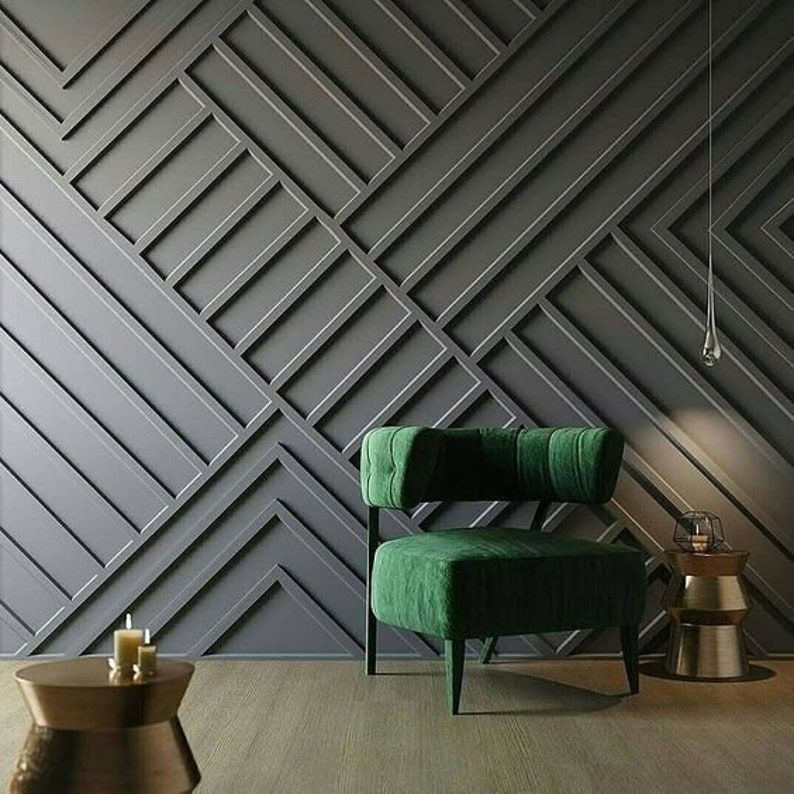 Dramatic grey geometric wall paneling with a green velvet chair, perfect for bespoke wallpaper installations.